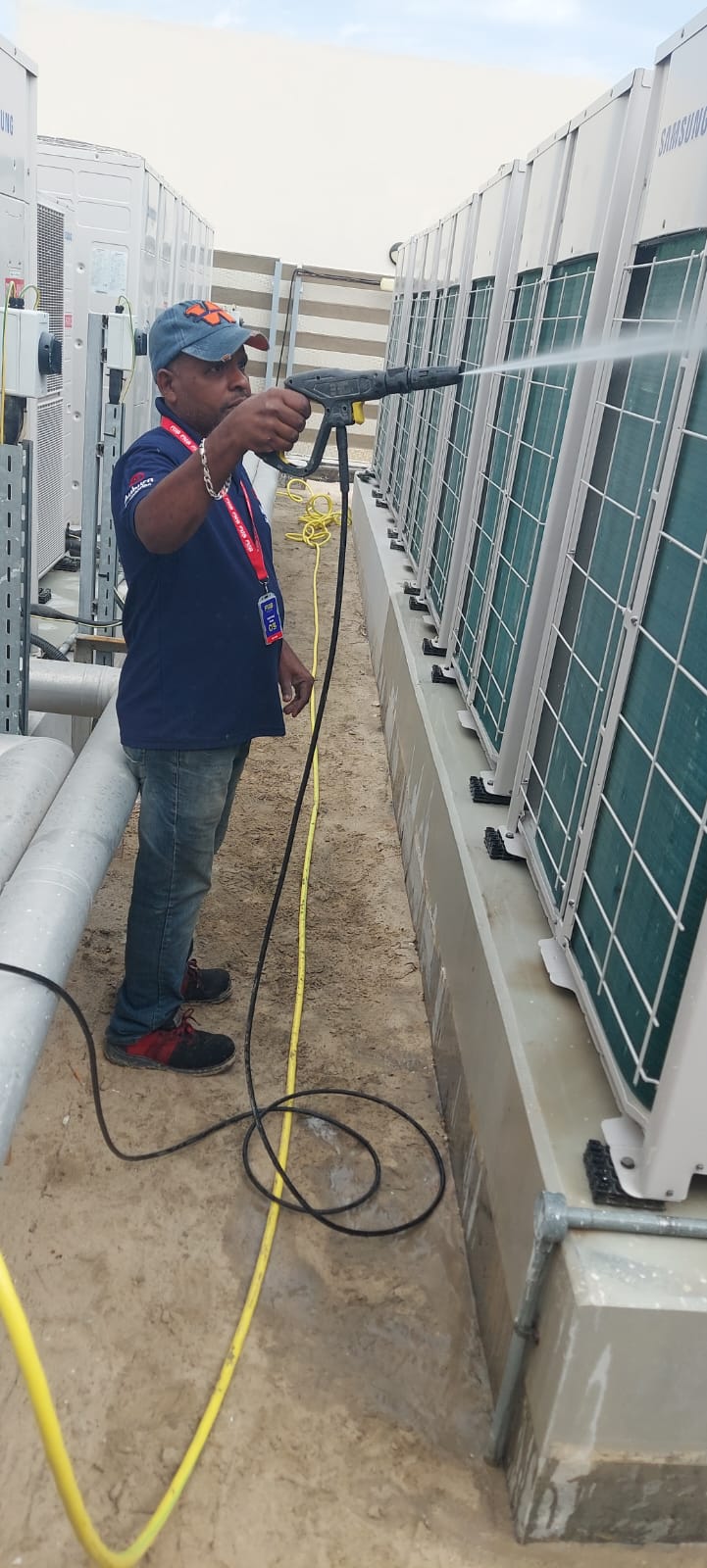Pressure-washing rooftop Samsung VRF condenser units during planned maintenance.